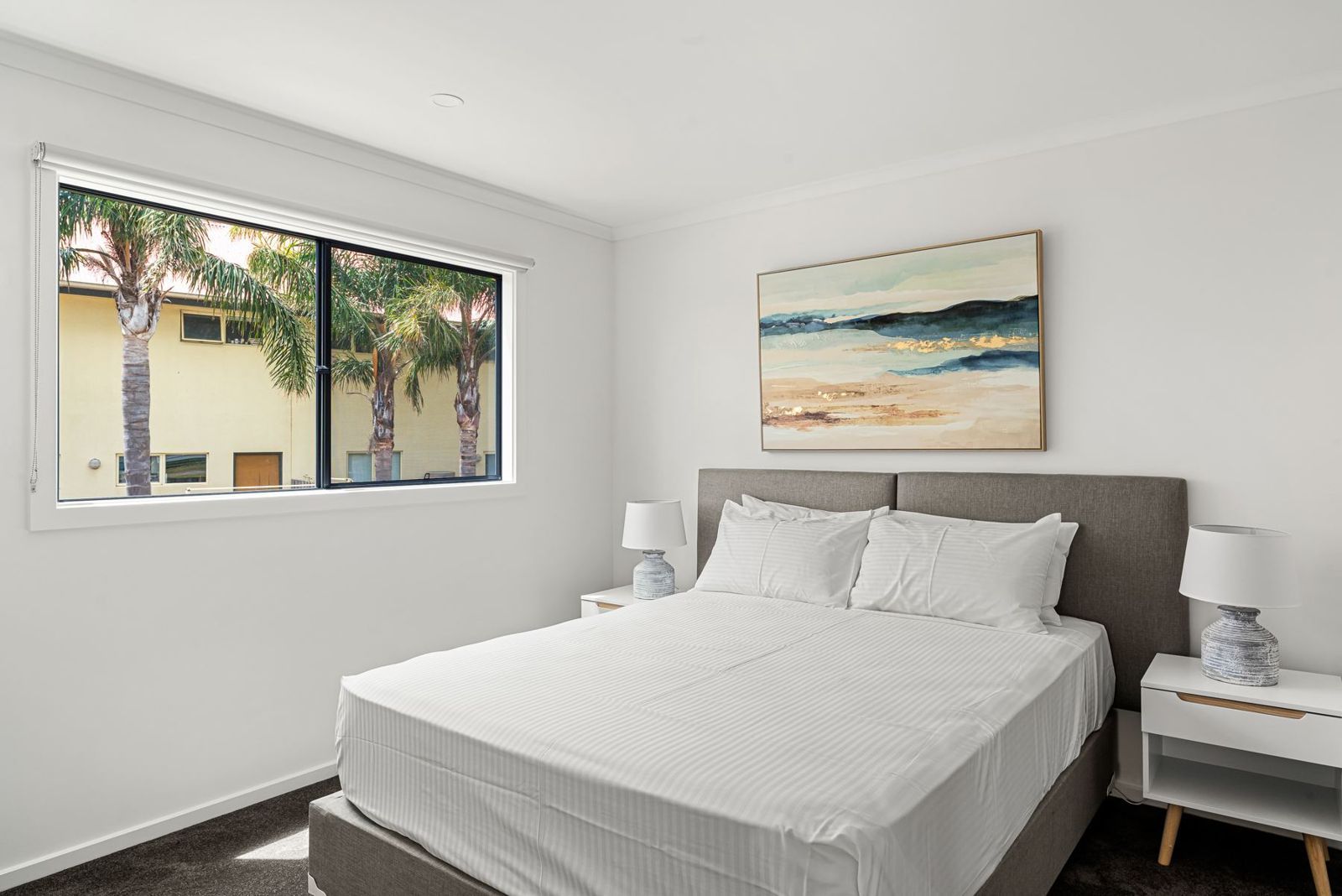 Main bedroom with queen bed and large window